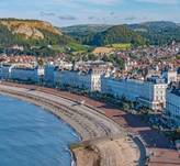 A beach with buildings and a body of water

Description automatically generated